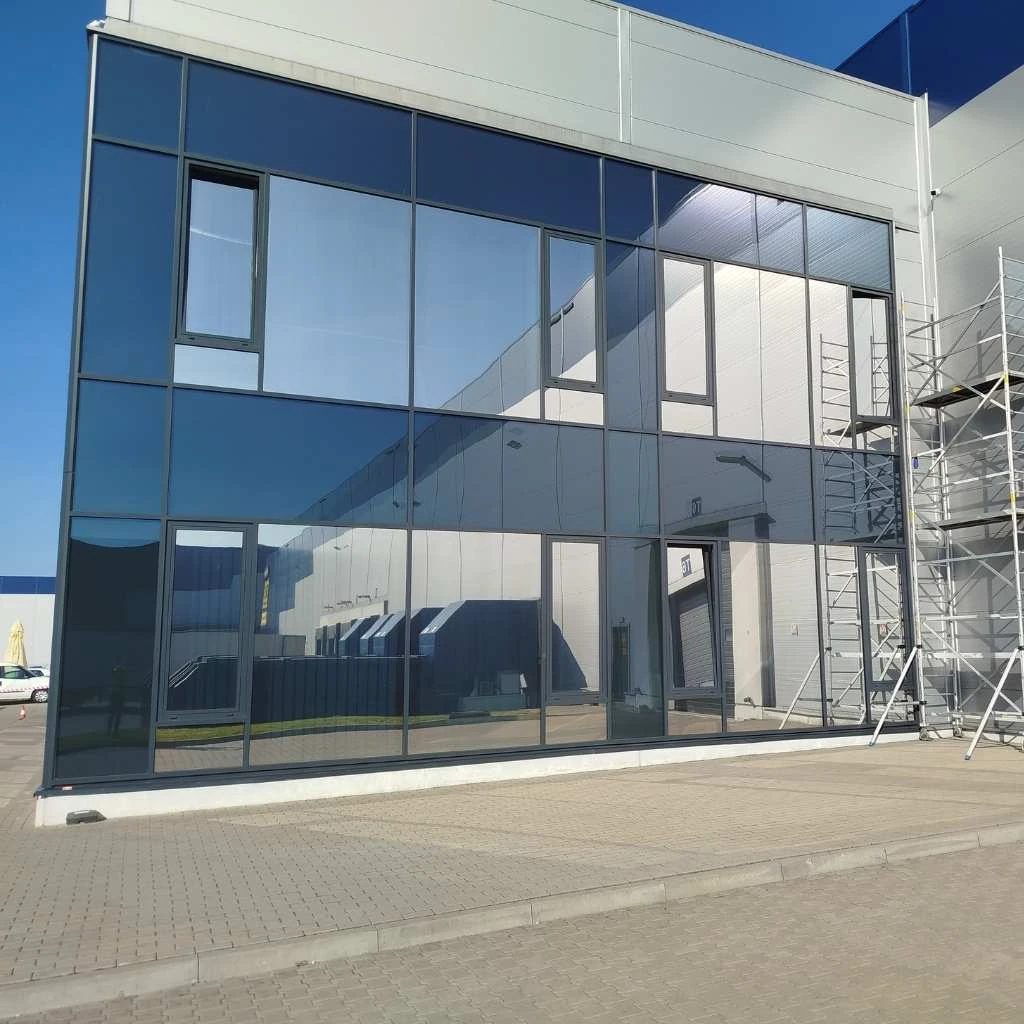 przyciemnione szyby z folią przeciwsłoneczną w nowoczesnym biurowcu